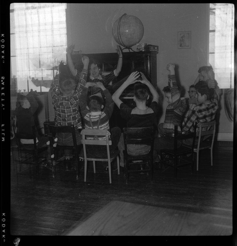 women-and-children-sitting-in-a-circle-around-piano-in-opportunity